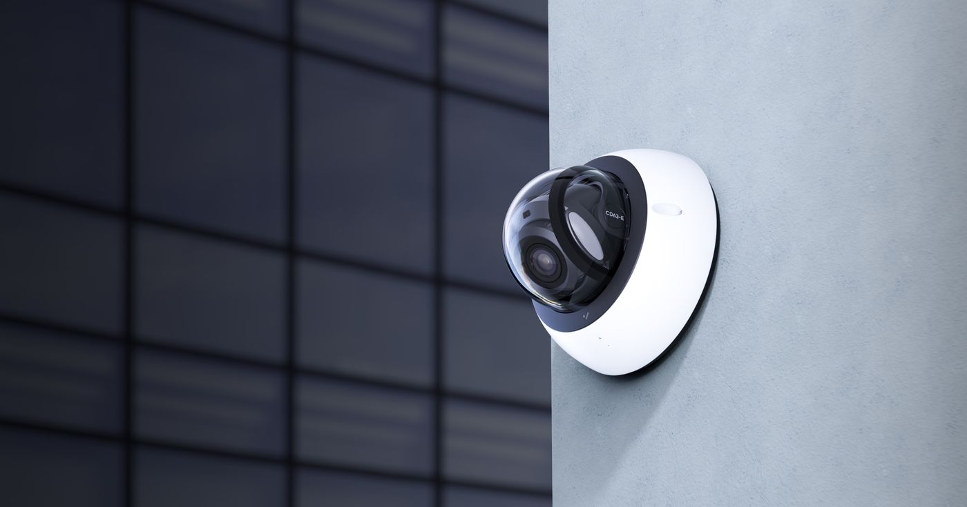 Verkada dome camera mounted on a wall corner, dark backdrop